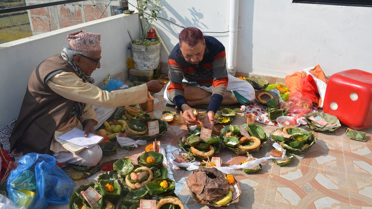A priest guiding a man through a shraddha ceremony, the pindas set out on leaf plates